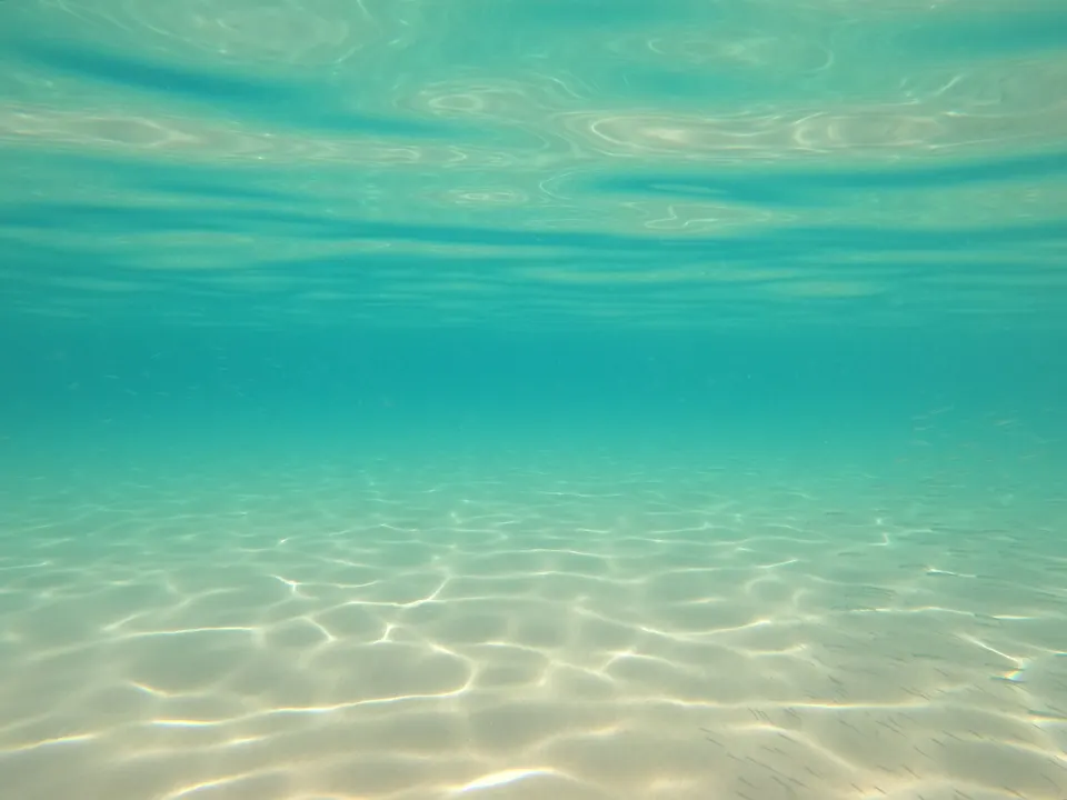 Sunlight on a sandy seabed in the shallow, clear water of the Adriatic.