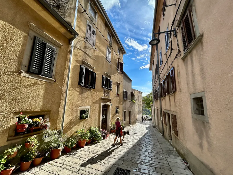 A lane in Buzet's old town, where many windows still have traditional shutters.