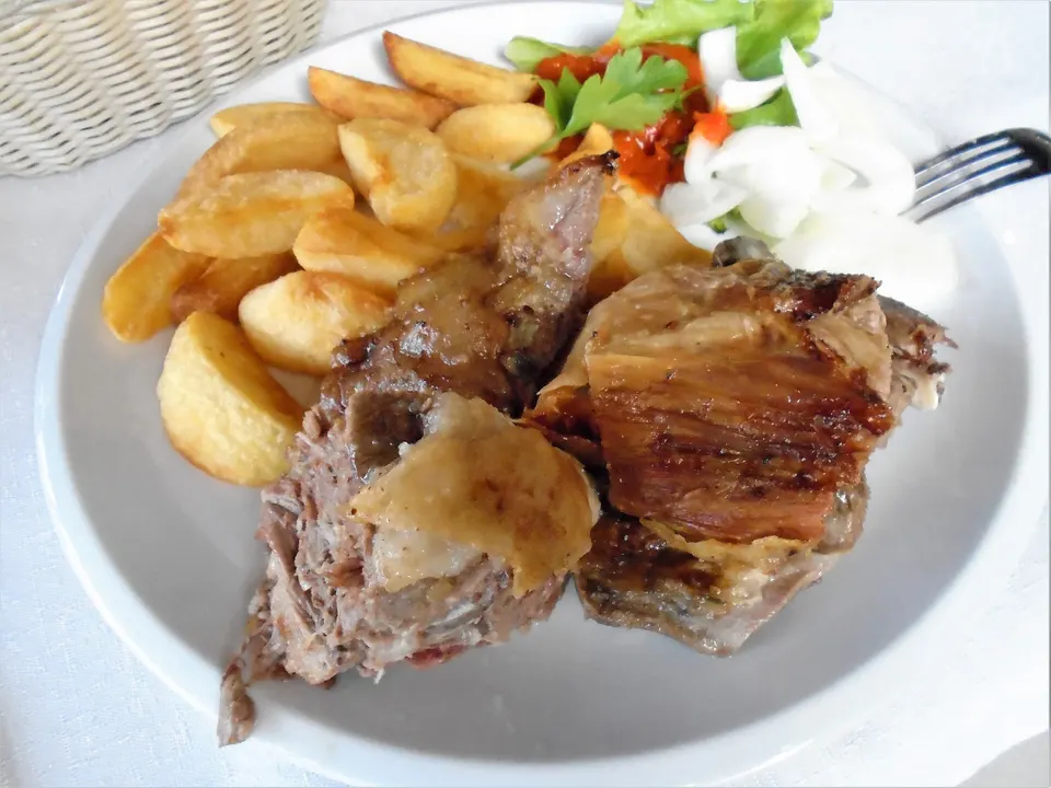 Roast lamb with potatoes and onion, served in a village near Vrsar.