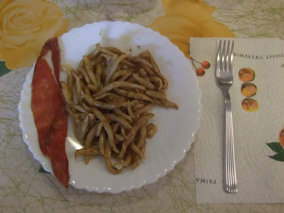 Pljukanci, the thin hand-rolled pasta of Istria, served with a slice of sausage.