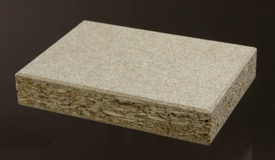 Particleboard in section: wood chips pressed with glue, with nothing to stop water at an open edge.