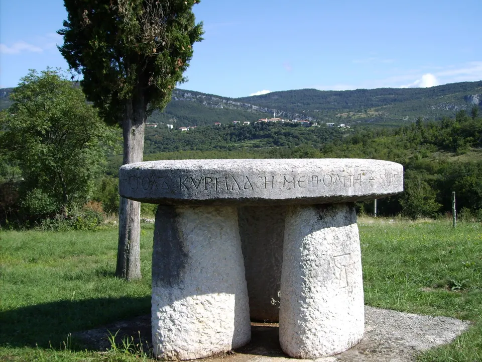 The stone Table of Cyril and Methodius on the Glagolitic Alley, with wooded hills in the background.