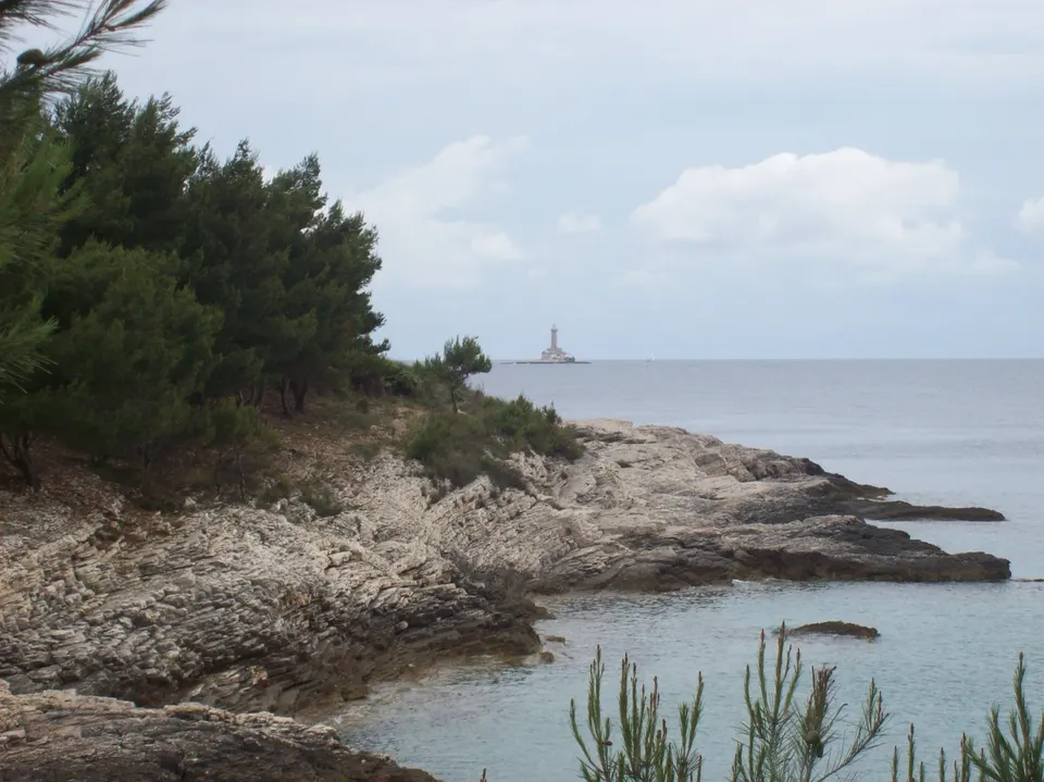 The Porer lighthouse on its islet, seen from the rocks of the cape.