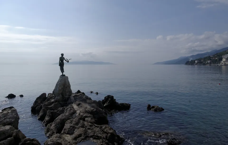 The Maiden with the Seagull on her rock off the Opatija shore, with the Kvarner Gulf beyond.
