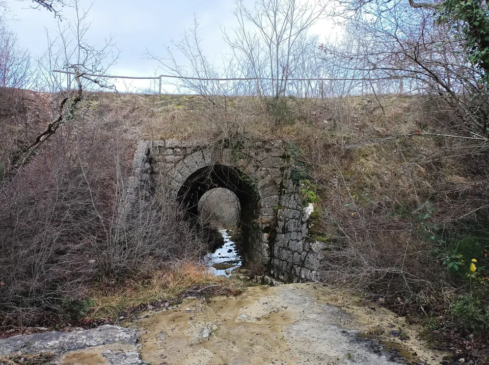 A stone arch beneath the old railway embankment near Vižinada; the cycle path runs above.