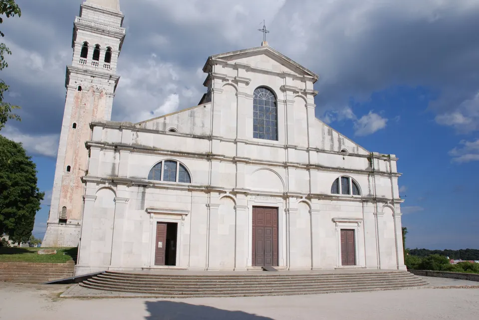 The white facade of the Church of St Euphemia, with its bell tower on the left.