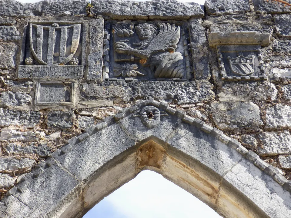 Stemmi e il leone alato di San Marco murati sopra una porta in pietra ad arco acuto a Sveti Lovreč.