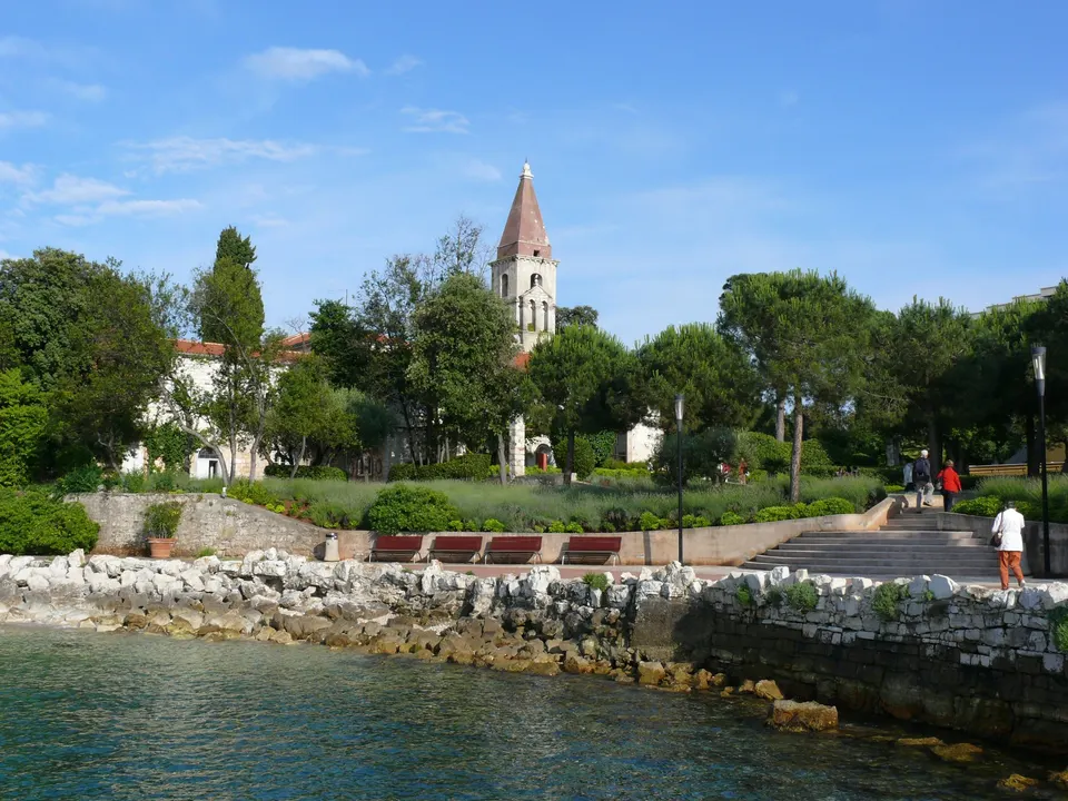 Das Ufer von Sveti Andrija, der größeren Hälfte von Crveni otok, mit dem alten Kloster und seinem Glockenturm zwischen den Bäumen.