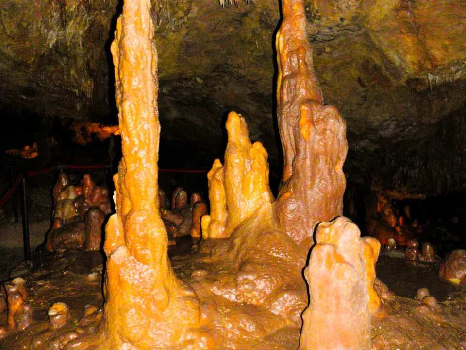 Orangefarbene Stalagmiten wachsen vom Boden der Höhle von Feštini bei Žminj empor.