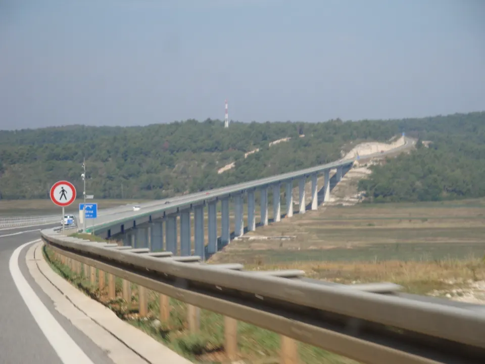 Il ponte dell'autostrada A9 attraversa l'ampia e verde valle del Quieto, visto dalla corsia di emergenza.