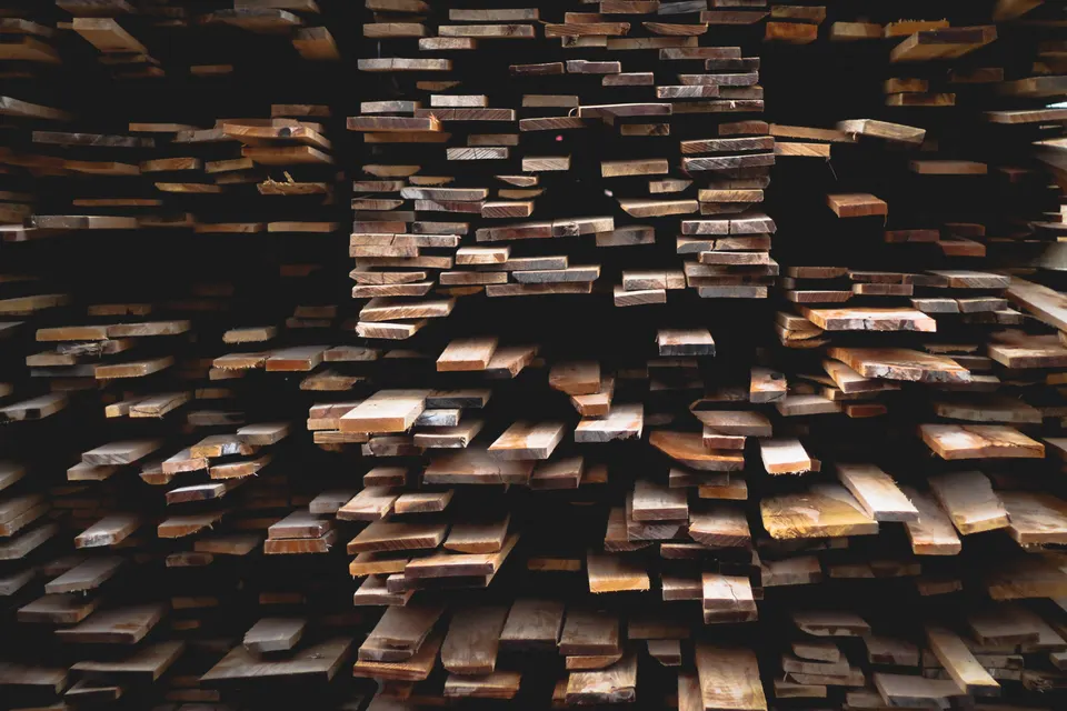 A stack of sawn boards seen from the end: each one is solid wood, and each one keeps taking up and giving off moisture long after it is made into furniture.