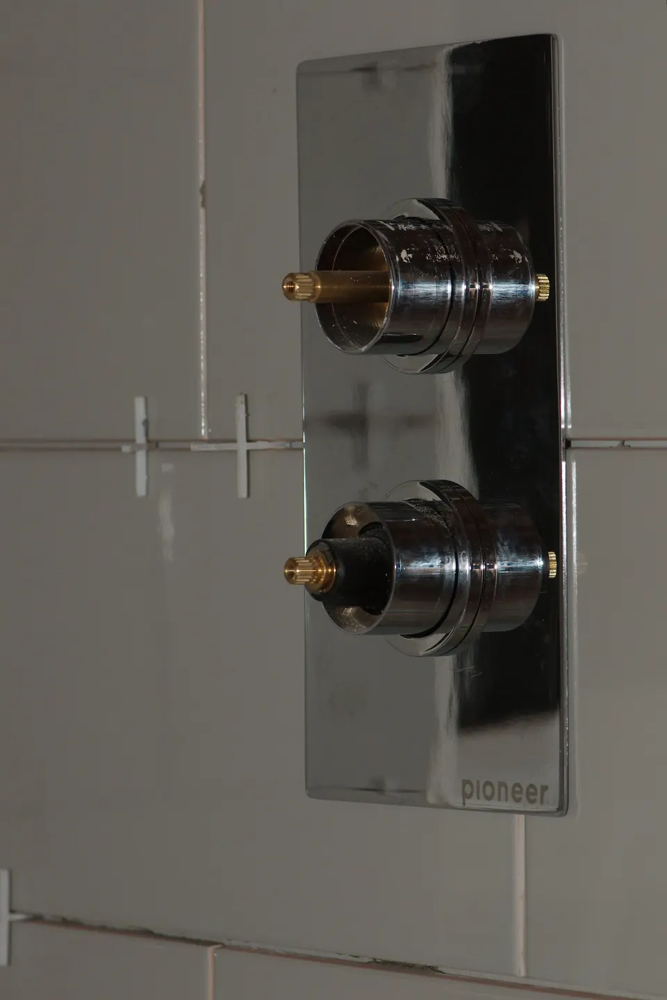 A shower valve with its chrome plate fitted but the handles still missing. Unfinished items like this belong on the snagging list.