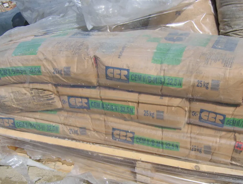 Bags of cement stacked on a pallet under plastic. Two quotes can name the same material and still price very different products.