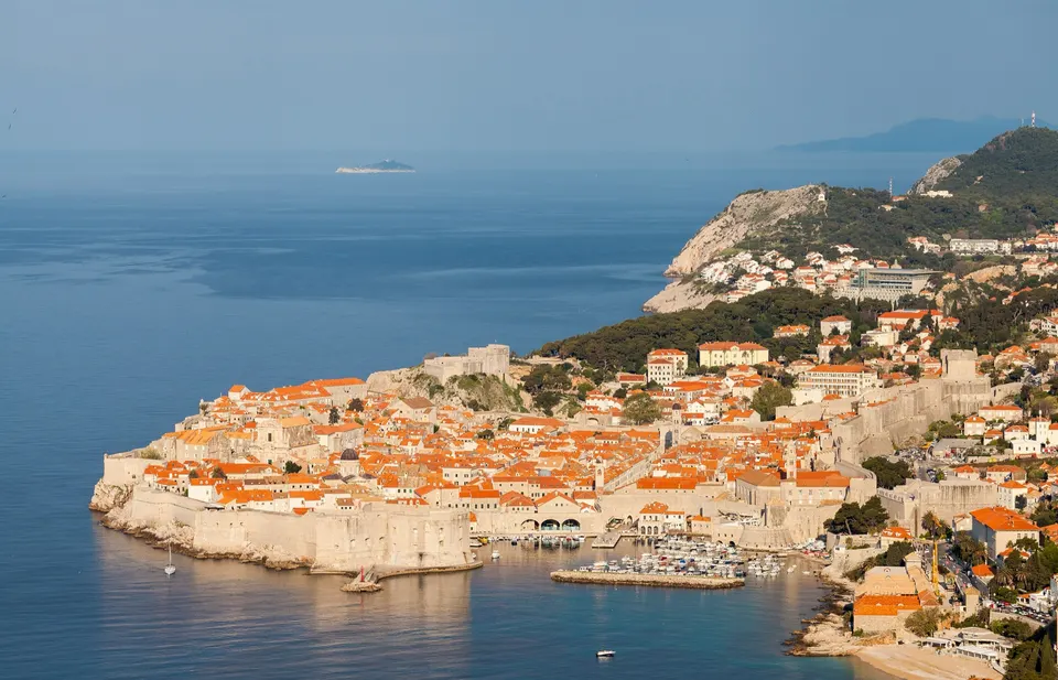 The walled old town of Dubrovnik on its rocky promontory, with the open sea and the coast beyond.