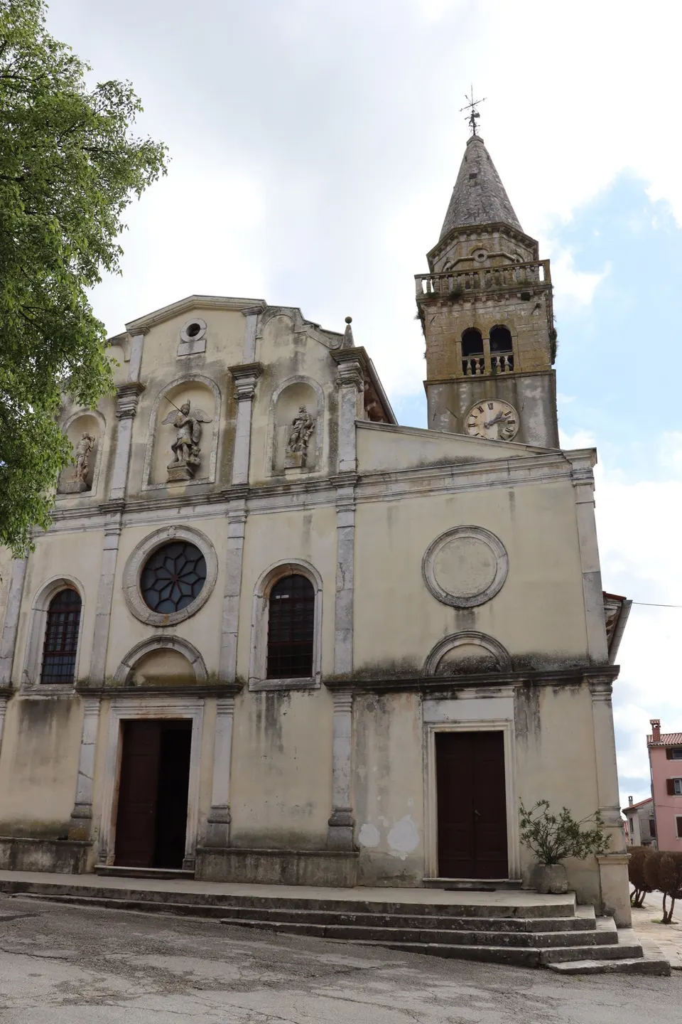 The baroque facade of the parish church of St Michael the Archangel in Žminj, with its bell tower beside it.
