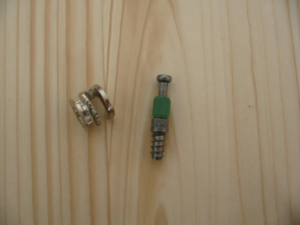 The two parts of a cam-lock connector, the small fitting that holds most self-assembly furniture together.